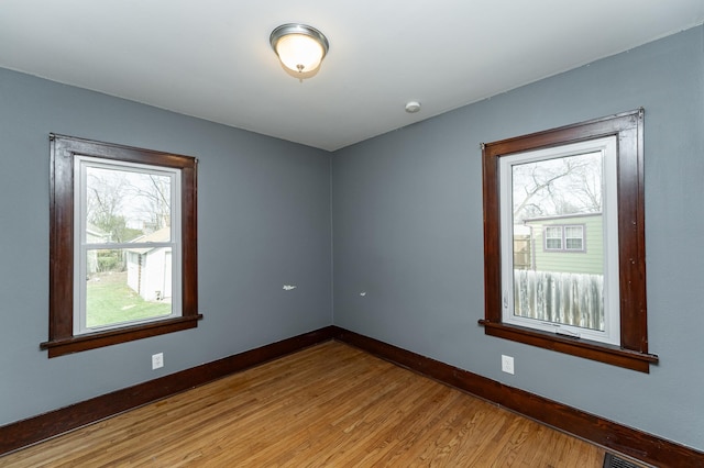 unfurnished room featuring baseboards and wood finished floors