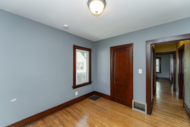 unfurnished bedroom with baseboards, visible vents, and light wood-style floors