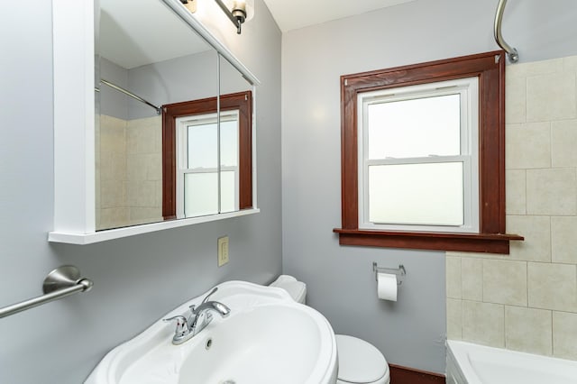 bathroom with a tub to relax in, a sink, walk in shower, and toilet