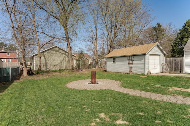 view of yard with central air condition unit, fence, an outbuilding, and a garage