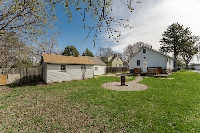 view of yard featuring an outdoor structure, a deck, and a fenced backyard