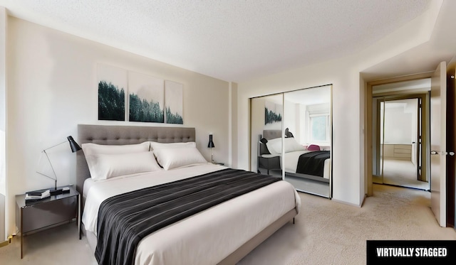 bedroom featuring light colored carpet, a textured ceiling, and a closet
