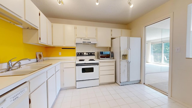 kitchen featuring white appliances, under cabinet range hood, a sink, and light countertops