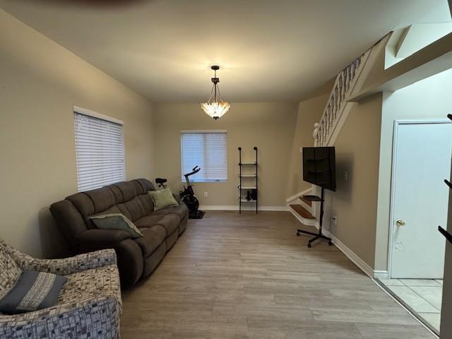 living room featuring baseboards and light wood-type flooring