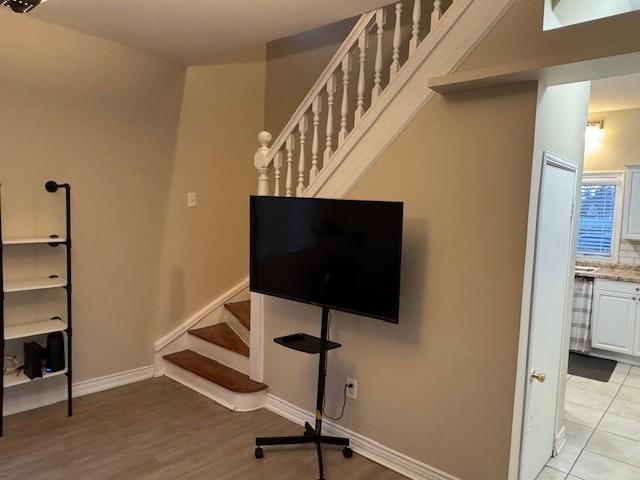 interior space featuring baseboards, light wood-style floors, and stairway