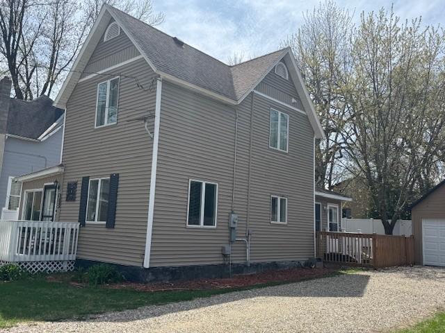 view of side of home with a shingled roof