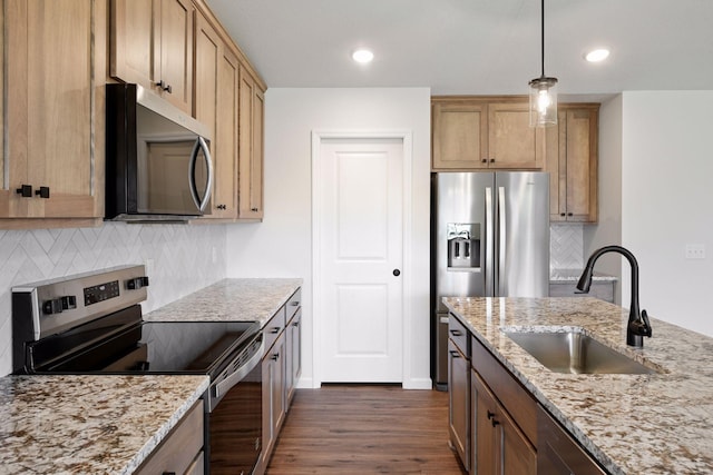kitchen featuring decorative backsplash, light stone countertops, dark wood-style floors, a sink, and appliances with stainless steel finishes