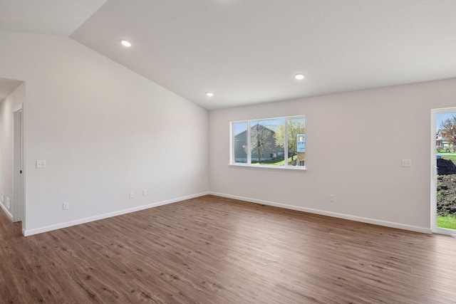 unfurnished room with baseboards, recessed lighting, lofted ceiling, and wood finished floors