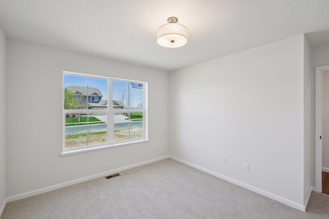 empty room with baseboards, carpet, and visible vents