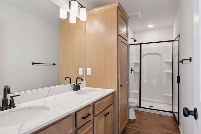 full bath with wood finished floors, a sink, a stall shower, and toilet