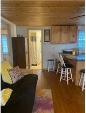 living room with dark wood-style floors, a healthy amount of sunlight, and wood ceiling
