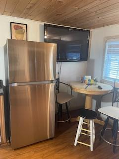 kitchen featuring freestanding refrigerator, breakfast area, wooden ceiling, and light wood-style flooring