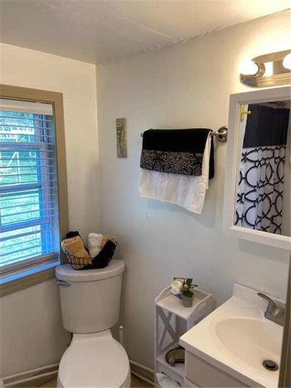 full bathroom with baseboards, vanity, and toilet