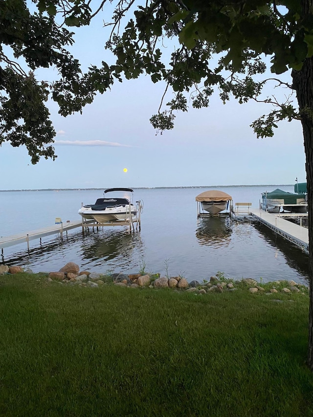 dock area with boat lift and a water view