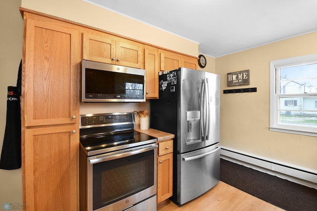 kitchen with light countertops, appliances with stainless steel finishes, a baseboard heating unit, and light wood finished floors