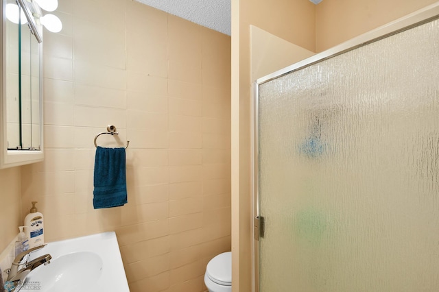 full bath with toilet, a sink, and a stall shower