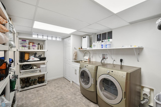 washroom featuring a sink, cabinet space, and independent washer and dryer