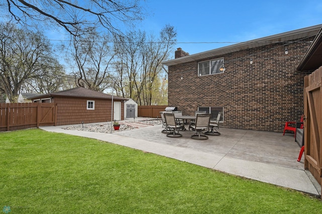 exterior space featuring an outdoor structure, a shed, a fenced backyard, a lawn, and a patio
