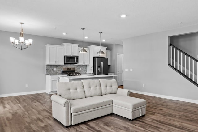 living area featuring baseboards, dark wood finished floors, and a chandelier