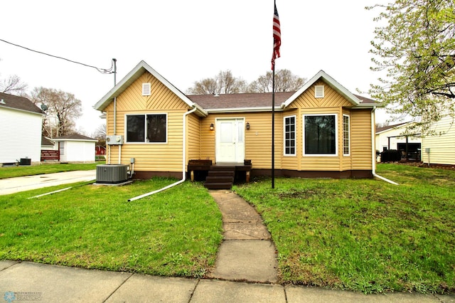 bungalow-style home featuring central air condition unit and a front yard