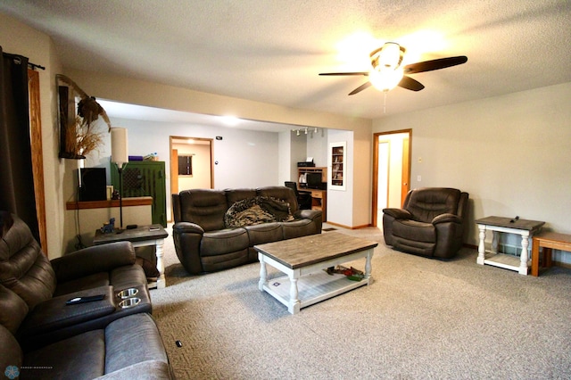 carpeted living area with a ceiling fan and a textured ceiling