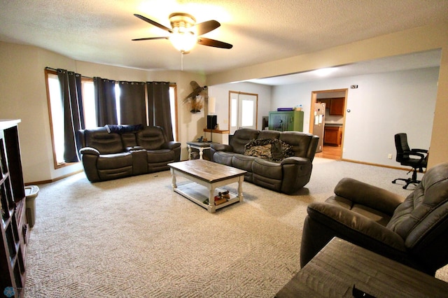living room featuring baseboards, carpet, and a ceiling fan