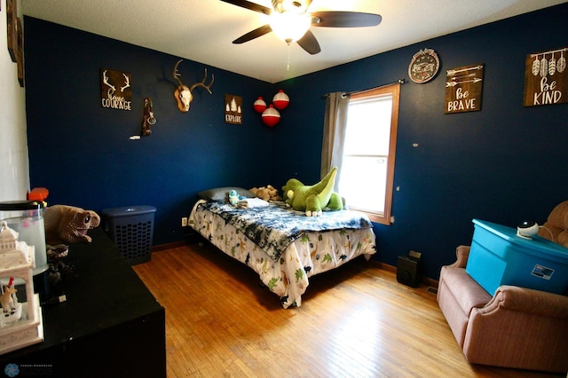 bedroom featuring baseboards, ceiling fan, and wood finished floors