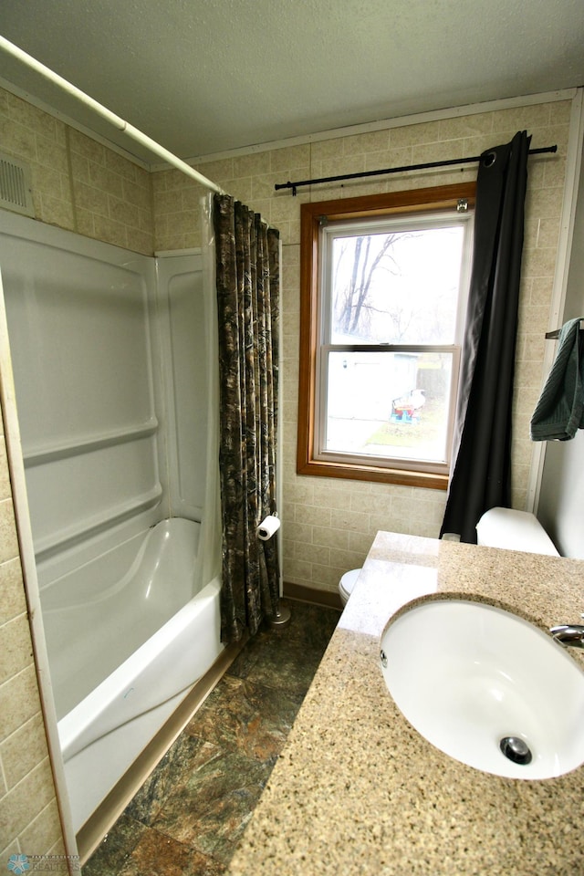 full bathroom featuring visible vents, vanity, toilet, a textured ceiling, and shower / bath combo