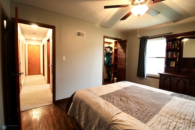 bedroom featuring ceiling fan, baseboards, wood finished floors, visible vents, and a closet