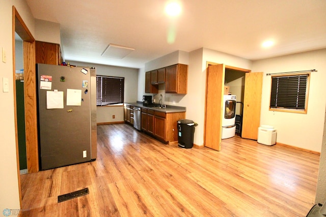 kitchen featuring visible vents, appliances with stainless steel finishes, light wood-type flooring, a sink, and baseboards