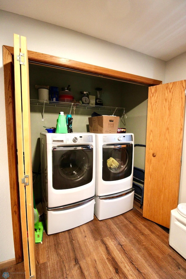 washroom featuring laundry area, independent washer and dryer, and wood finished floors