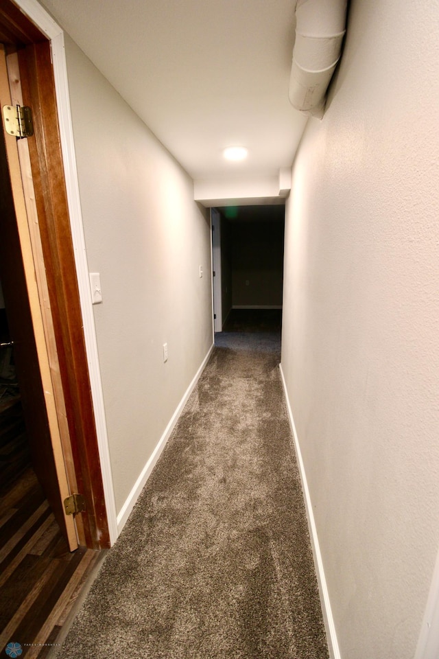 corridor with baseboards and carpet