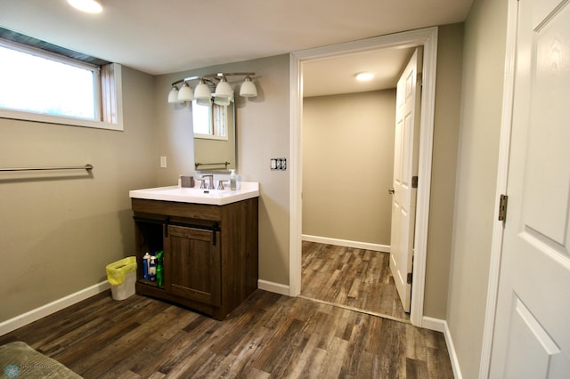 bathroom with baseboards, wood finished floors, and vanity