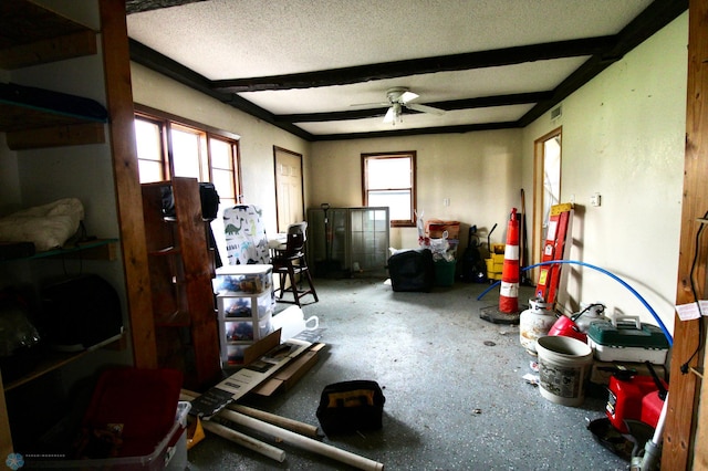 living room with a ceiling fan and beam ceiling
