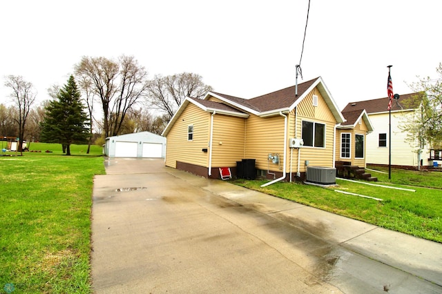 back of property with a garage, central air condition unit, an outdoor structure, and a lawn