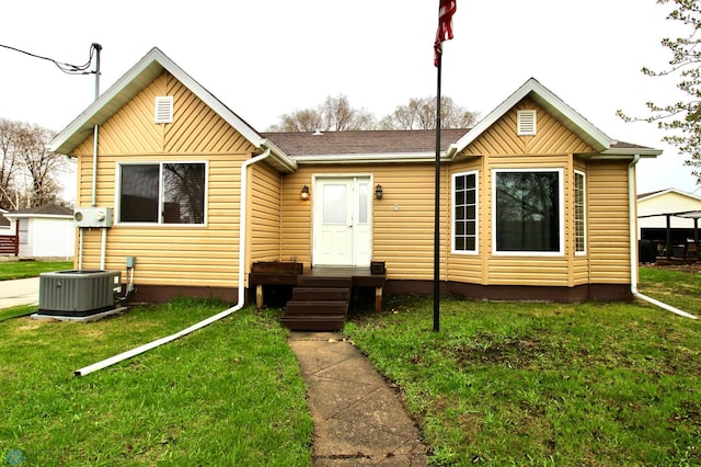 view of front of house with a front lawn and cooling unit