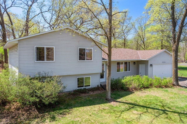 view of front of property with an attached garage and a front lawn