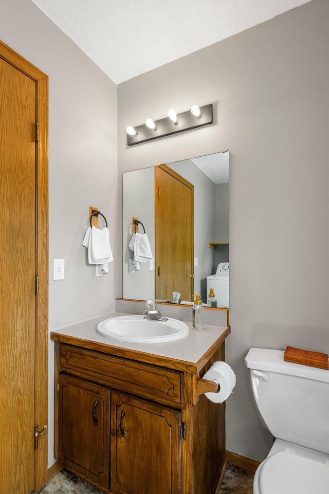 half bath featuring toilet, vanity, and baseboards