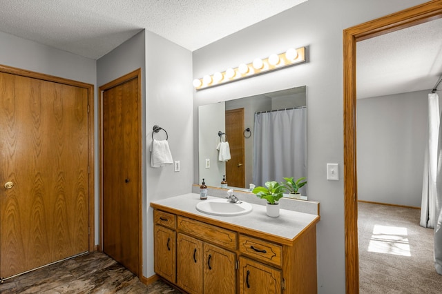 full bath featuring a textured ceiling and vanity