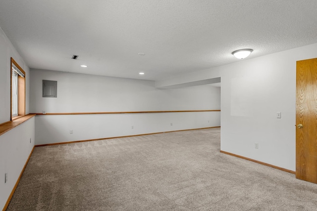 carpeted spare room featuring baseboards, a textured ceiling, and recessed lighting