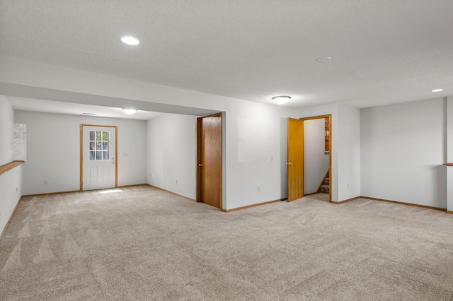 basement with carpet flooring, stairs, baseboards, recessed lighting, and a textured ceiling