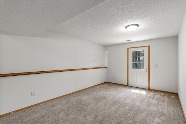 unfurnished room with carpet floors, a textured ceiling, and baseboards
