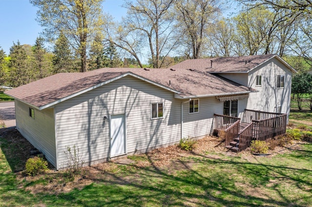 rear view of house featuring a deck and a shingled roof