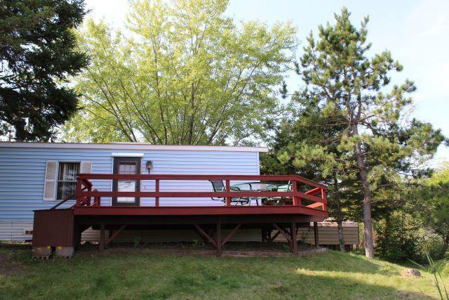 rear view of property with a wooden deck and a yard