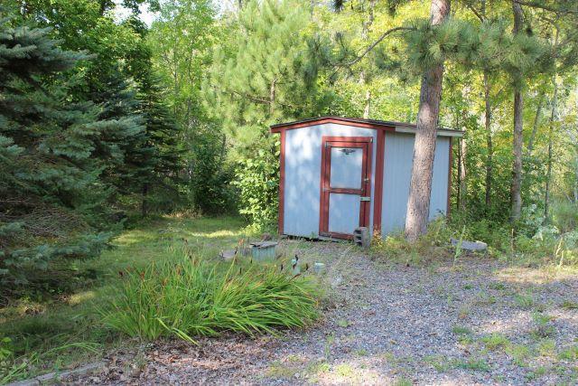 view of shed with a view of trees