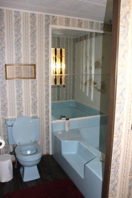 bathroom with wallpapered walls and toilet