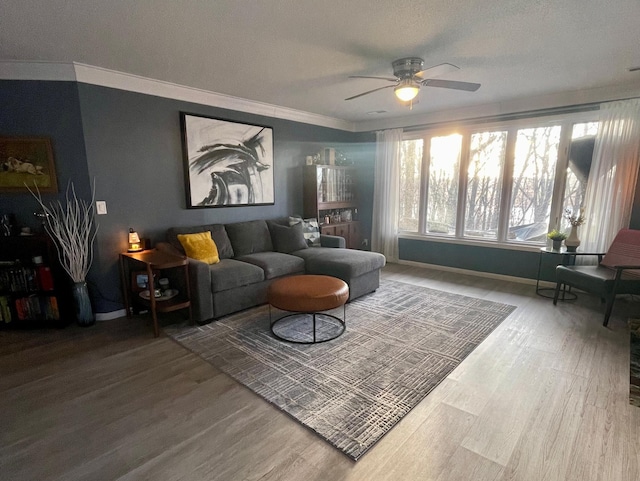 living room with baseboards, ornamental molding, ceiling fan, and wood finished floors