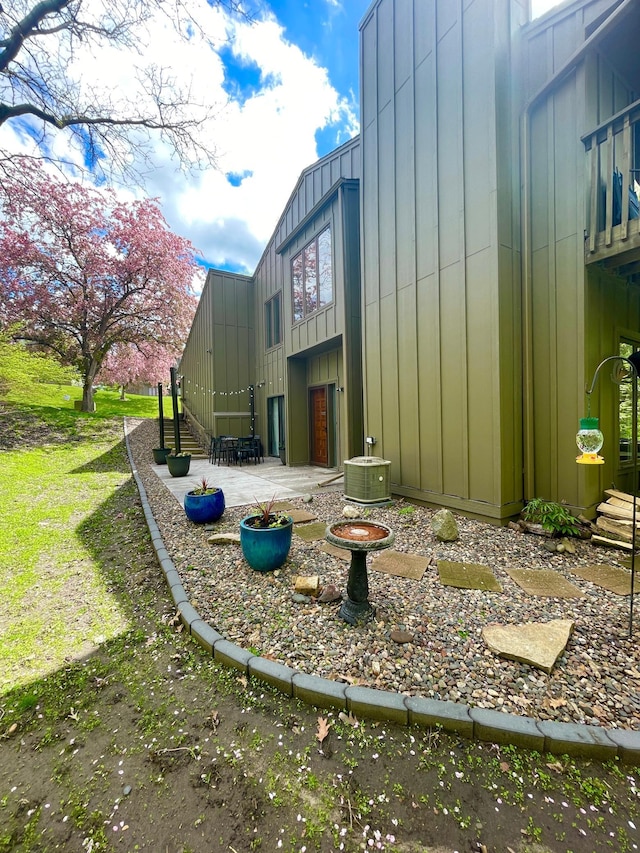 view of yard with central air condition unit and a patio