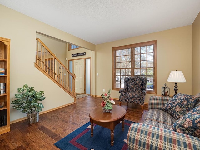 living room with baseboards, wood finished floors, and stairway