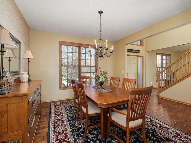 dining area featuring baseboards, dark wood finished floors, plenty of natural light, and an inviting chandelier